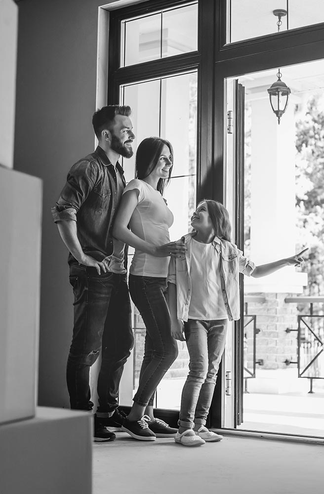 Happy father, mother and daughter surrounded by moving boxes in their new house after a home inspection